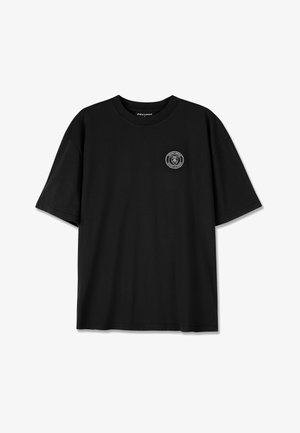 T-shirt de algodão preto com mangas curtas, com um logo bordado circular na área do peito esquerdo e um design de ajuste descontraído.