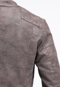 Graue Lederjacke mit glatter Textur, gestickten Schulterakzenten und einem taillierten Design mit Nahtdetails auf dem Rücken.