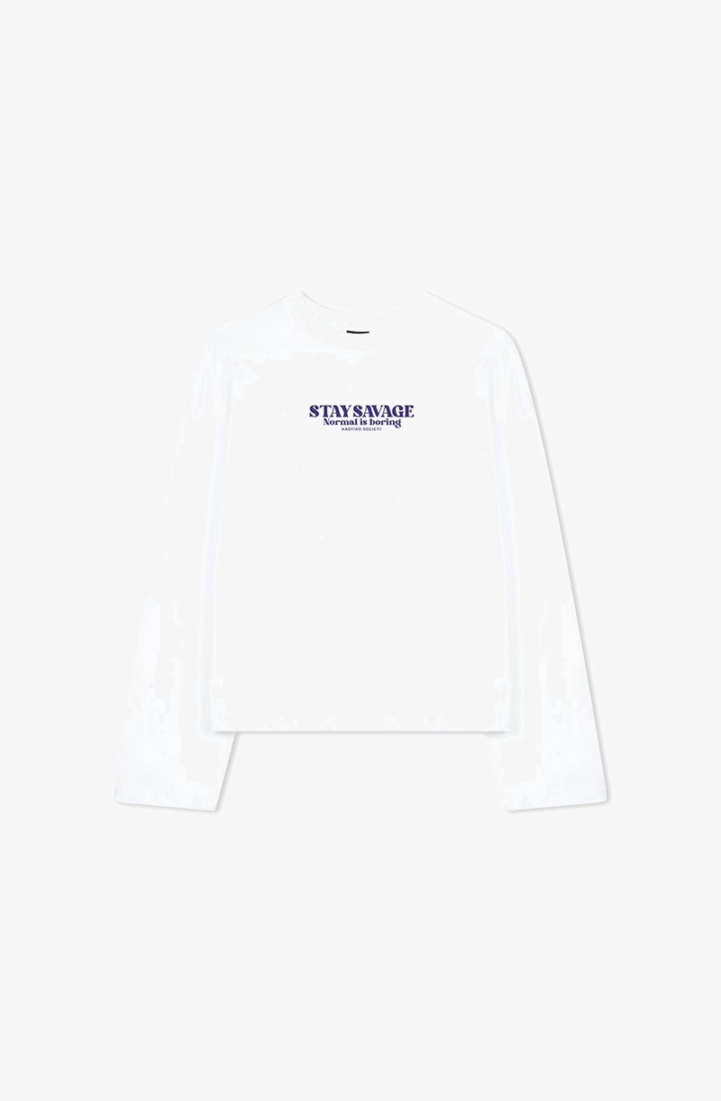 White long-sleeve t-shirt featuring a crew neckline and a cropped design. Text printed in purple reads "STAY SAVAGE Normal is boring."