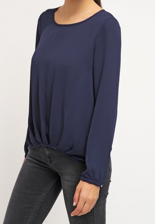 Námořnická modrá blůza s dlouhými rukávy a kulatým výstřihem, se nařasením v pase a knoflíkovými detaily na manžetách. Hladká textura.