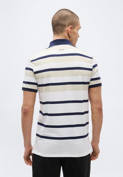 Homme vu de dos portant un polo à manches courtes avec des rayures horizontales bleu marine et beige et un col bleu marine.