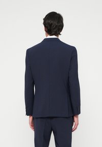 Σακάκι ναυτικού στυλ από υφασμάτινη ύλη με υφή, διαθέτει έναν κενό στο πίσω μέρος, κοφτές πέλες και κουμπωτούς καρπούς.