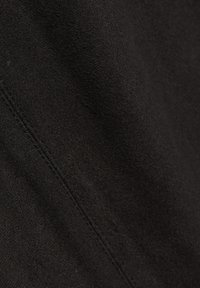 Zwart suède stof met een zachte, textuurrijke oppervlakte en zichtbare stiknaden, wat een subtiel patroon en diepte creëert.