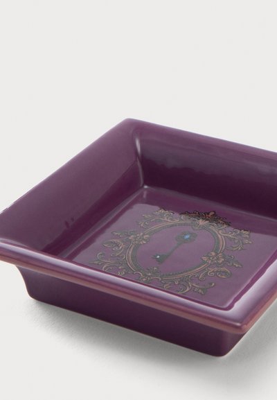 Plat carré violet brillant avec des bords surélevés et un motif décoratif de clé vintage au centre entouré de motifs floraux ornés.