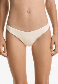 Chilot de baie de tip bikini în țesătură ribbed de un bej deschis. Prezintă un design cu talie joasă, cu benzi laterale înguste și o textură netedă.