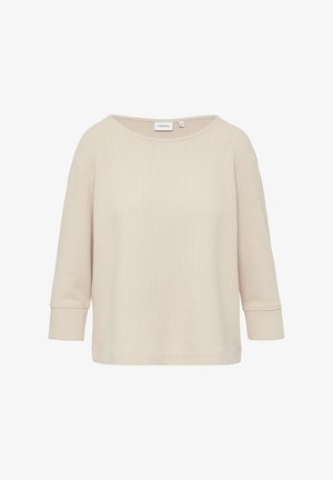 Beżowa bluzka z dzianiny w waflowy wzór, o luźnym kroju, okrągłym dekolcie i rękawach trzy czwarte, z delikatną teksturą i przeszyciami na mankietach.