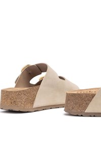 Sandali con piattaforma in suede beige, suola in sughero, apertura sul retro e ampia cinghia con ritagli circolari per la ventilazione.