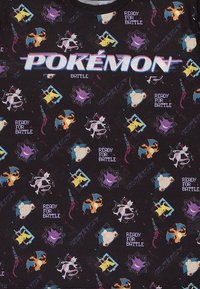 Černé bavlněné tričko s barevnými grafikami Pokémonů, na kterém jsou zobrazeni různí hrdinové a text "POKÉMON BATTLE" výrazně vystupuje.