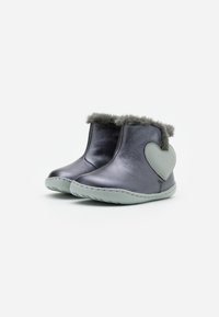 Bottes chelsea en cuir gris métallique avec un bord en fourrure grise douce et un accent en forme de cœur vert. Semelles en caoutchouc souple pour plus de confort.