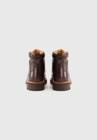 Pair of brown leather boots with padded collars, sturdy soles, and pull tabs viewed from the back on a plain background.