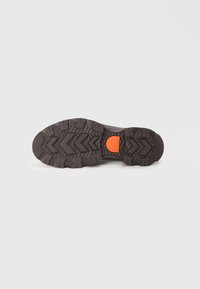 Must musta musta zigzag mustriga ja oranži ümmarguse logoga. Omab sügavaid sooni haardeks ja vastupidavuseks.