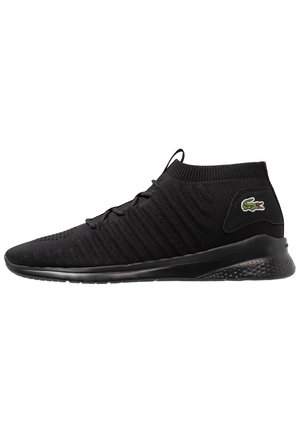 Black knit high-top sneaker with textured sole, subtle lace-up design, and small green crocodile logo on the side heel.