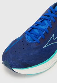 Blauwe hardloopschoen met een gestructureerde bovenkant, met gemusterd gaas en contrasterende turquoise accenten op de zool en veters.