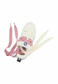 Baskets blanches avec une tige texturée, dotées de lacets à motif zigzag rouge et de lacets plats couleur crème. Étiquette de logo noire sur le talon.