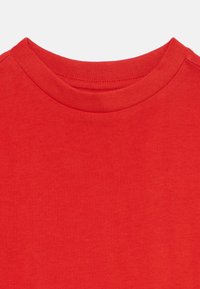 Rød bomulls t-skjorte med rund ribbet halslinning og jevn tekstur, uten synlige mønstre eller aksenter.