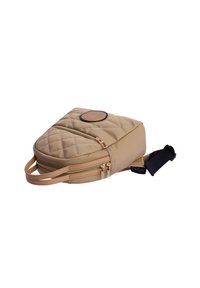 Bolso cruzado acolchado en tono beige con dos cremalleras, un parche circular con el logo y una correa ajustable. Fabricado en un material suave y texturizado.