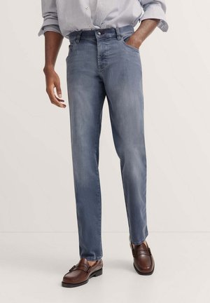 Men's light blue denim jeans featuring a straight leg design, five pockets, and a mid-rise waist. Worn with brown leather loafers.