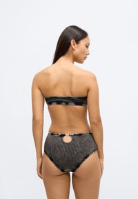 Set de bikini cu un top bandeau în dungi negre și gri, cu margini fără cusături, și un slip cu talie înaltă, cu un detaliu decupat circular în partea din spate.