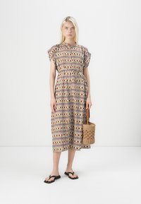 Printet midi-kjole i let stof med korte puffærmer, en indsnævret talje og et mønster af rektangler i nuancer af beige, rød og grøn. Vævet håndtaske.