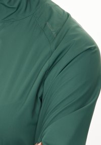 Groene shirt met korte mouwen van zachte, gladde stof, met een ronde kraag, subtiele stiksels en merknaam op de schouder.