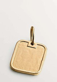 Colgante cuadrado de oro con superficie texturizada y bordes redondeados en un lazo de oro sobre un fondo claro y sencillo.