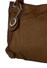 Bruine leren handtas met een gladde textuur, voorzien van zilverkleurige hardware, grote ringen en een decoratieve ketting met een hartvormige bedel.