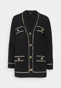 Černý kardigan s hlubokým výstřihem do V, zlatými knoflíky, předními kapsami a barevným tkaným lemováním podél okrajů a kapes.