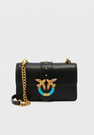 Fekete bőr kézitáska arany láncszíjjal, arany madár alakú kapoccsal türkiz részlettel, valamint apró arany tüskékkel az elülső fedélen.
