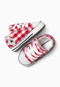 Sneakers in tela a quadri rossi e bianchi con suole in gomma bianca, lacci e dettagli a righe nere. Presentano un logo circolare sul lato.