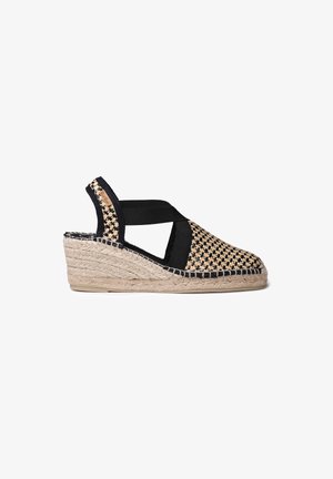 Wedge espadrille en toile tissée avec des sangles en tissu noir et une semelle en jute naturel. Comprend une tige à motifs et un détail en corde enroulé sur le talon.