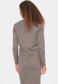 Grijze top met lange mouwen gemaakt van zachte stof, heeft een ronde hals en een slim-fit ontwerp, zichtbaar van achteren met textuurlokken.