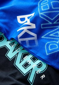 Kaks üksteise kohale pandud t-särki. Ülemine on sinine valge graafilise tekstiga. Alumine on must türkiissinise graafilise tekstiga ja geomeetriliste mustritega.