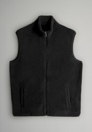 Svart fleeceväst med hög krage, framzipper och två sidofickor. Mjuk textur och utan ärmar, designad för värme och komfort.