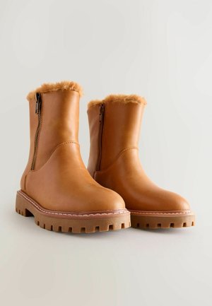 Brune læder ankelstøvler med en faux fur krave, lynlåslukning i siden og en tyk, robust sål med et mønster.