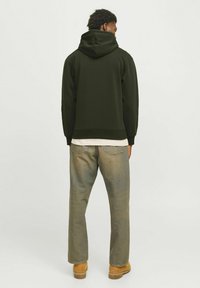 Mørkeblå hoodie med en stor justerbar hætte, ribbede manchetter og kant. Sæts sammen med lyse denim jeans og brune fodtøj. Bagbekræft.