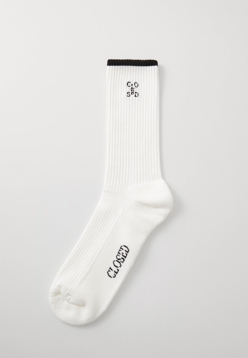 White ribbed sock with black cuff. Features "CLOSED" logo in black on the ankle and toe areas. Regular length for comfortable fit.