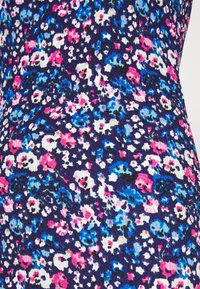 Tessuto a motivi floreali con sfondo blu scuro e fiori rosa, bianchi e turchesi. La texture è a coste e strutturata.