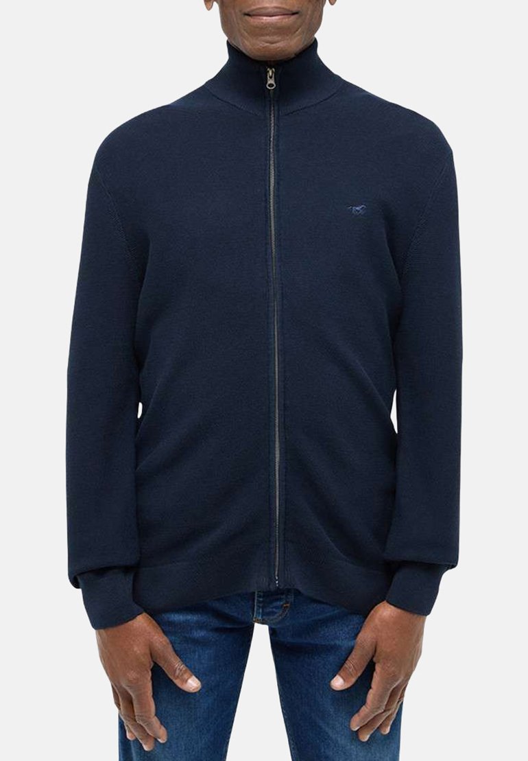 Navy spalvos zip-up megztinis su aukštu apykakle, ilgomis rankovėmis, guma apdirbtais rankogaliais ir lygiu paviršiumi. Yra mažas logotipas ant krūtinės.