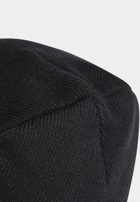 Czarna dziana czapka beanie o teksturowanym wykończeniu, z zaokrągloną kopułą i widocznymi detalami w szwach. Wykonana z miękkiego, elastycznego materiału.