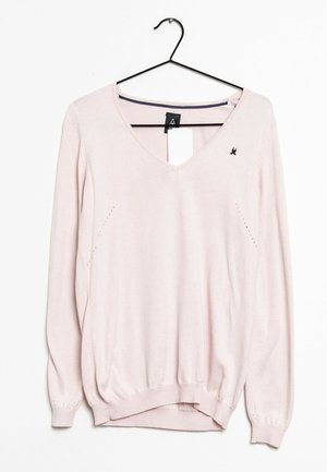 Vaaleanpunainen pitkähihainen neule, jossa on V-kaula-aukko, röyhelöhelma ja hihansuut. Siinä on pieni brodeerattu logo rinnassa ja hienovaraiset sivusaumat.