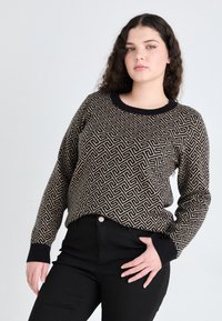 Sweter dzianinowy w beżowo-czarnym geometrycznym wzorze, z okrągłym dekoltem i czarnymi mankietami. Zestawiony z czarnymi dżinsami o wysokim stanie.