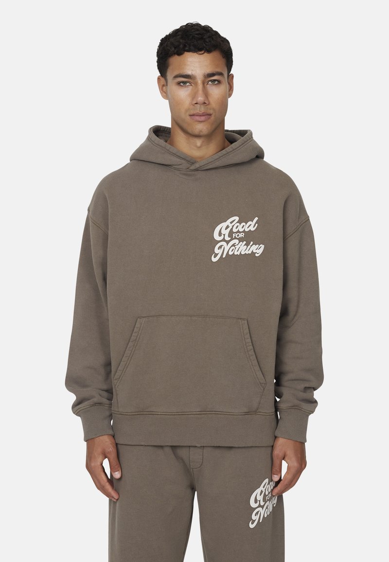 Hoodie in cotone marrone con tasca a marsupio e polsini a costine, con il testo bianco "Good for Nothing" sul petto. Abbinato a pantaloni tuta coordinati.