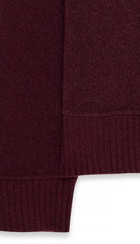 Burgundijas džemperis ar teksturētu adījumu, ribotām piedurknēm un gludu ķermeni. Apdares malas izceļ dizainu.