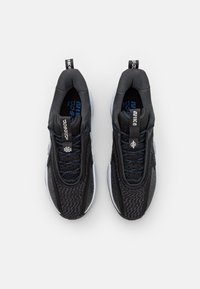 Baskets de sport noires avec une tige texturée, des accents bleus et des détails réfléchissants. Elles présentent des lacets et un col rembourré pour le confort.