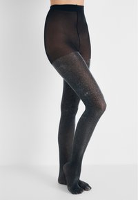 Svarta genomskinliga strumpbyxor med en glittrande silvergradient, med en mjuk textur och hög midja, som sträcker sig ner till tårna.