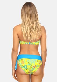 Zestaw bikini z żółtą bazą i kolorowymi wzorami tropikalnych liści, ozdobiony jednolitą niebieską taśmą w talii i zapięciem z tyłu.