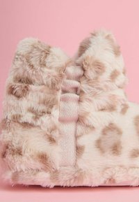 Purūs, šviesiai rožiniai imitacinės kailio šlepetės su leopardų raštais, su satino juostele gale, tekstūruota paviršiumi ir apvalia forma.