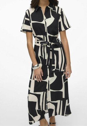 Kurzarmhemdkleid in Schwarz und Creme mit geometrischen Mustern, Knopfleiste, tailliertem Gürtel und Seitenschlitzen. Glatte Stoffoberfläche.