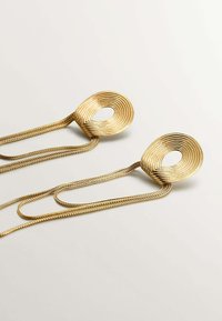 Pendientes de color dorado con un diseño en espiral, que cuentan con una abertura ovalada y largas cadenas retorcidas para colgar. Textura suave y acabado brillante.