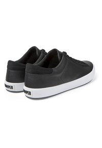 Musthave nahkast spordijalatsid siledast tekstuurist, madala profiiliga, valge kummitald ja peen bränding kandadel. Paeltega disain.